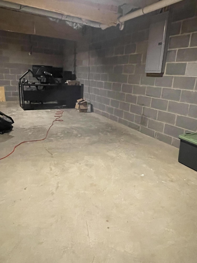 unfinished basement with concrete block wall and electric panel