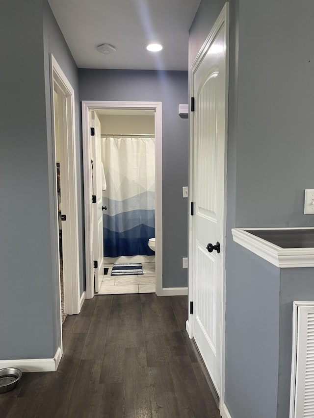 corridor featuring baseboards, dark wood-type flooring, and recessed lighting