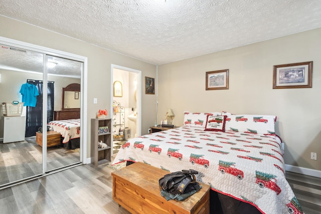 2895 Looney Rd, Parrottsville, TN 37843 - bedroom with wood finished floors, a closet, a textured ceiling, baseboards, and ensuite bath
