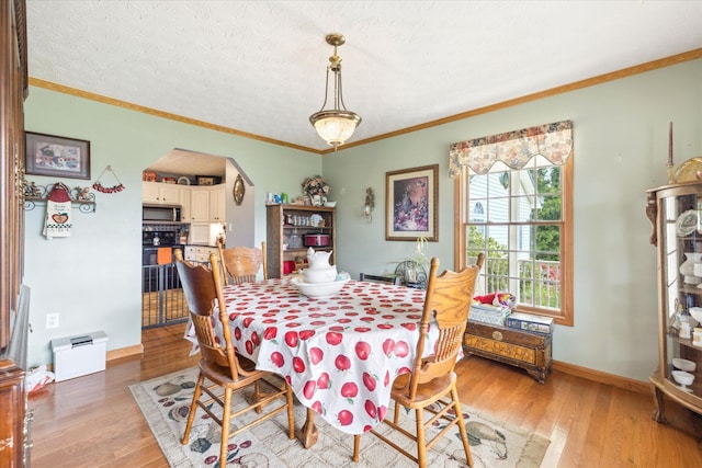 2895 Looney Rd, Parrottsville, TN 37843 - dining area with arched walkways, light wood-style flooring, ornamental molding, baseboards, and a textured ceiling