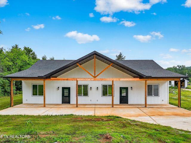 1570 W Dumplin Valley Rd, Dandridge, TN 37725 - back of property with a patio, a yard, and roof with shingles