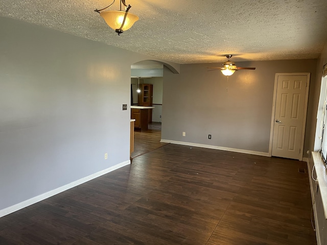 spare room featuring ceiling fan, dark hardwood / wood-style floors, and a textured ceiling