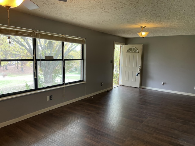 spare room with dark hardwood / wood-style flooring and a textured ceiling