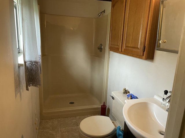 bathroom with tile patterned floors, toilet, a shower, and sink