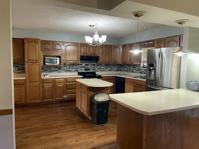 kitchen featuring a center island, dark hardwood / wood-style flooring, range hood, pendant lighting, and appliances with stainless steel finishes