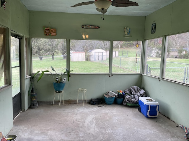 unfurnished sunroom featuring a wealth of natural light and ceiling fan