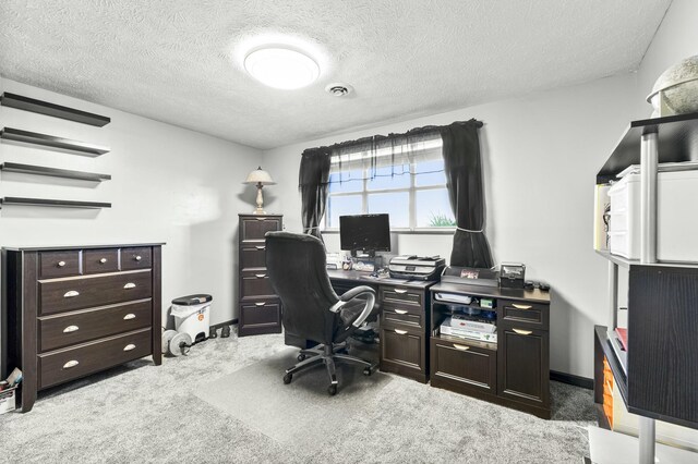 carpeted office space with visible vents and a textured ceiling