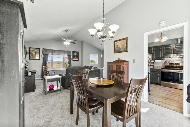 dining space with vaulted ceiling, baseboards, light carpet, and ceiling fan with notable chandelier