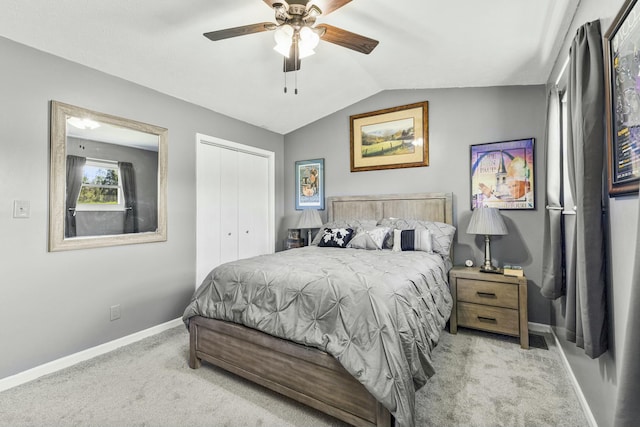 bedroom with vaulted ceiling, a closet, baseboards, carpet flooring, and ceiling fan