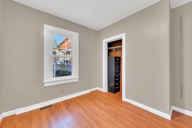 unfurnished bedroom with visible vents, light wood-style flooring, and baseboards