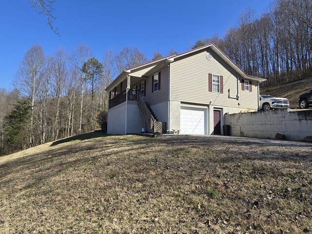 view of property exterior featuring stairway and an attached garage