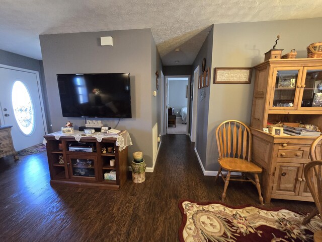 living room with baseboards, a textured ceiling, and wood finished floors