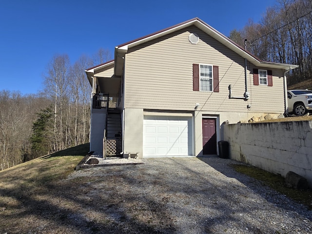 view of home's exterior with gravel driveway and a garage