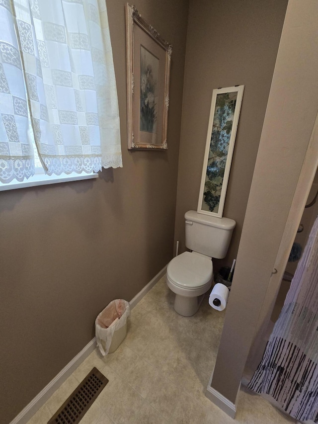 bathroom with toilet, visible vents, and baseboards