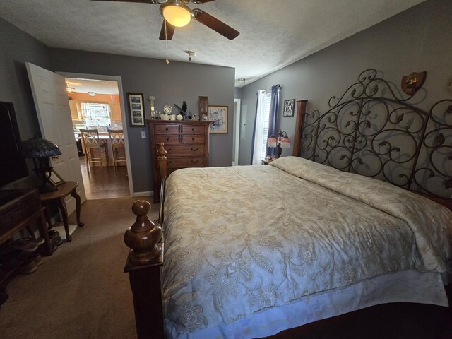 bedroom featuring a textured ceiling, ceiling fan, and carpet flooring