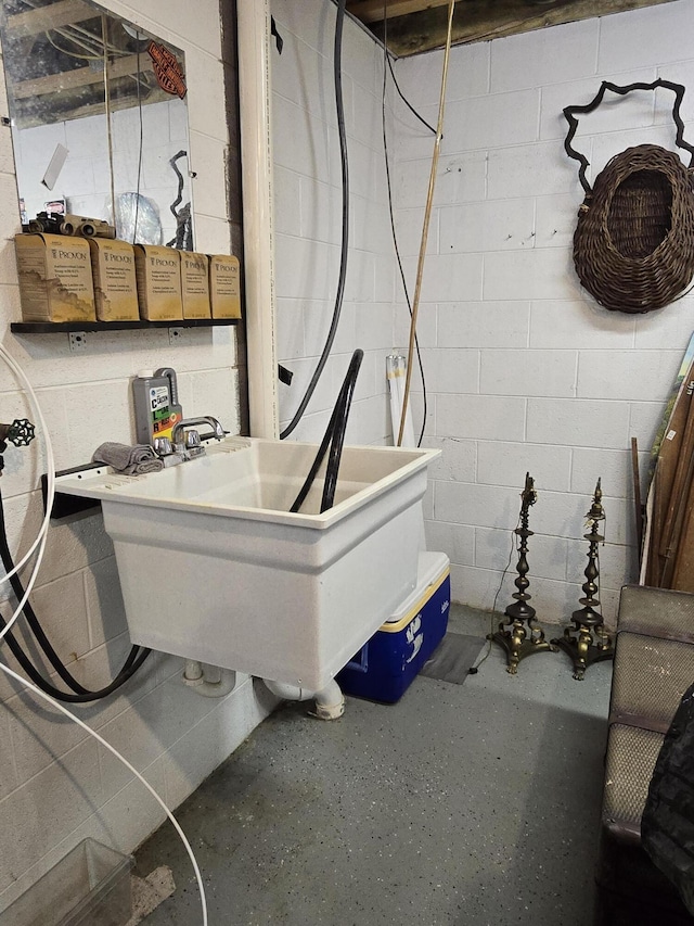 interior space featuring concrete block wall and a sink