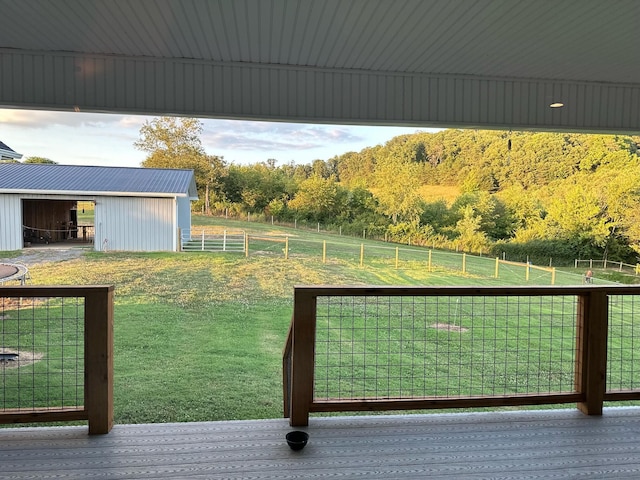 exterior space featuring a lawn, a rural view, and an outdoor structure