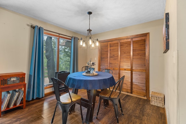 dining space with a notable chandelier, dark hardwood / wood-style floors, and a textured ceiling