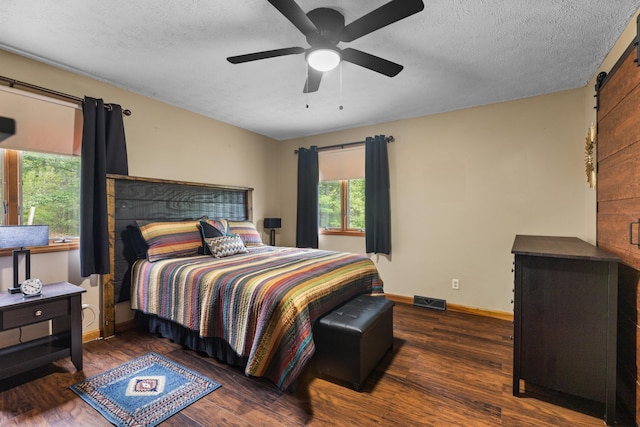 bedroom featuring a textured ceiling, ceiling fan, and dark wood-type flooring