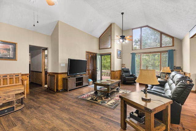 living room featuring a textured ceiling, dark hardwood / wood-style flooring, high vaulted ceiling, and ceiling fan