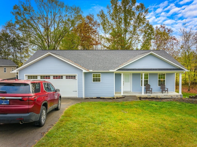 ranch-style house featuring a garage, covered porch, and a front lawn