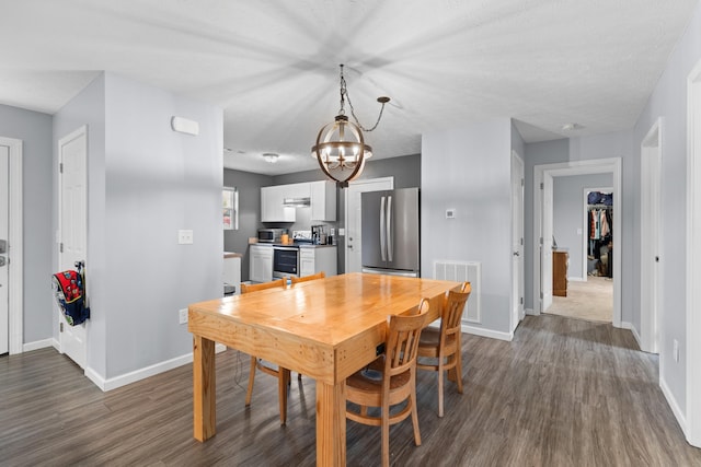 dining area with dark hardwood / wood-style flooring and a chandelier