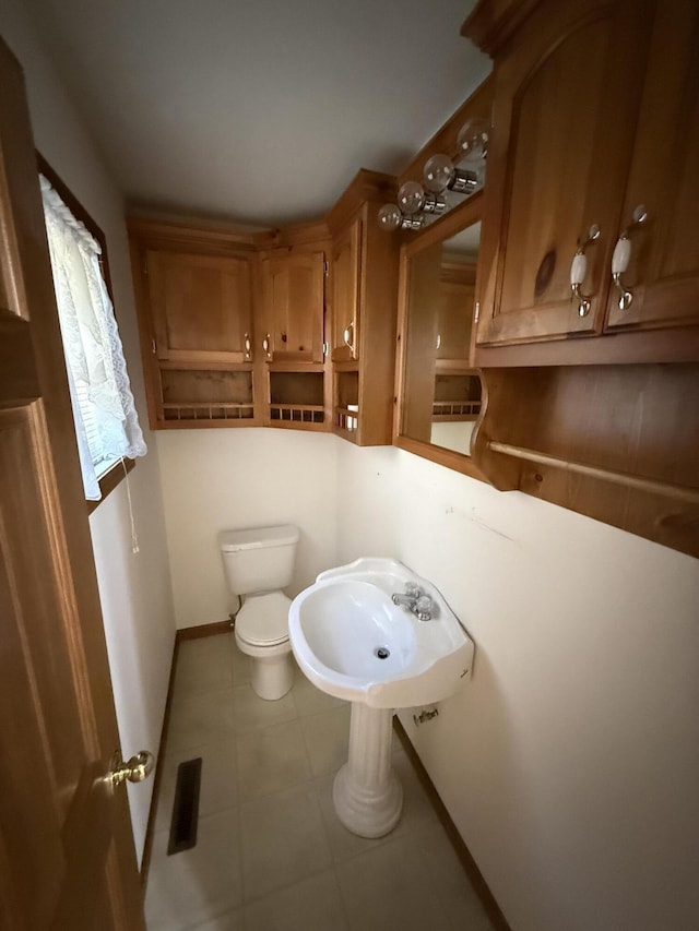 bathroom featuring a sink, toilet, and baseboards