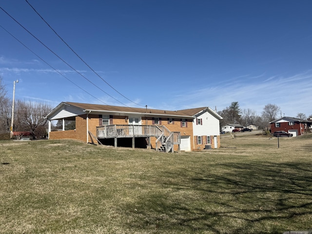 rear view of property featuring brick siding, a yard, stairway, and a wooden deck