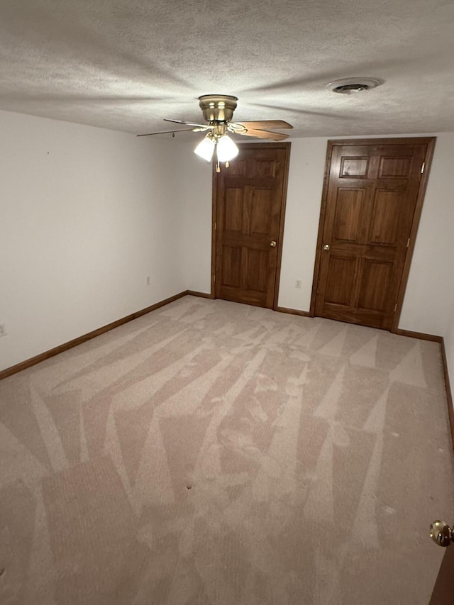 unfurnished room featuring light carpet, baseboards, visible vents, and a textured ceiling