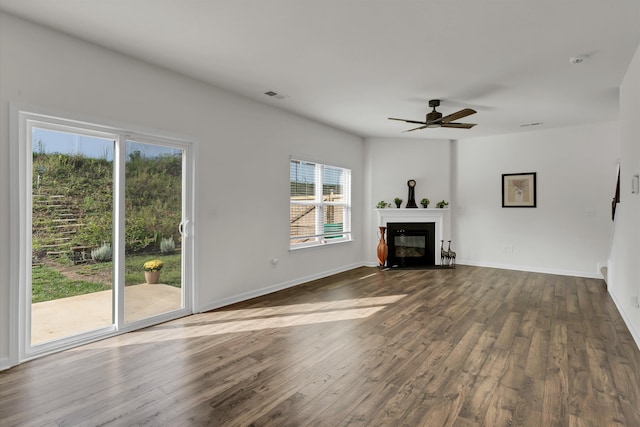 unfurnished living room featuring ceiling fan, a healthy amount of sunlight, and hardwood / wood-style flooring