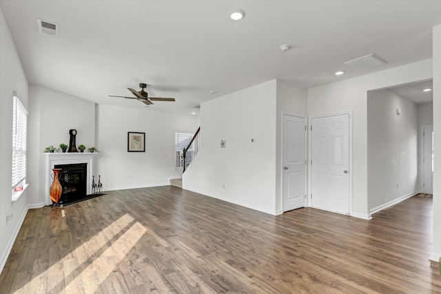 unfurnished living room featuring dark hardwood / wood-style floors and ceiling fan