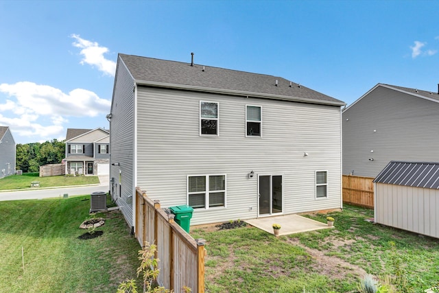 back of property with a lawn, central air condition unit, and a patio