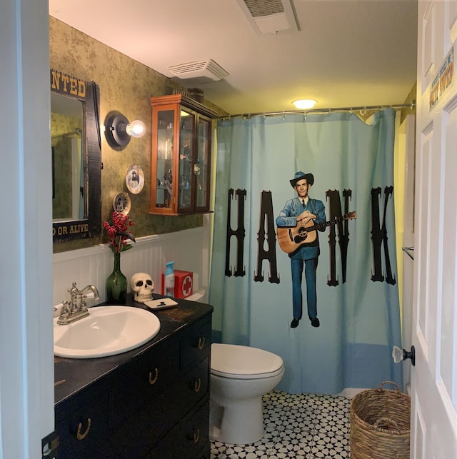 full bathroom featuring visible vents, toilet, wainscoting, wallpapered walls, and vanity