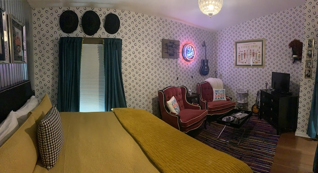 bedroom featuring wallpapered walls and lofted ceiling