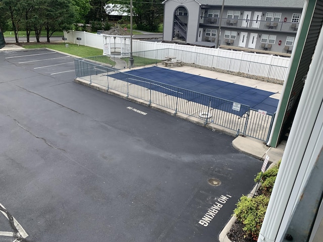 community pool with a patio area and fence