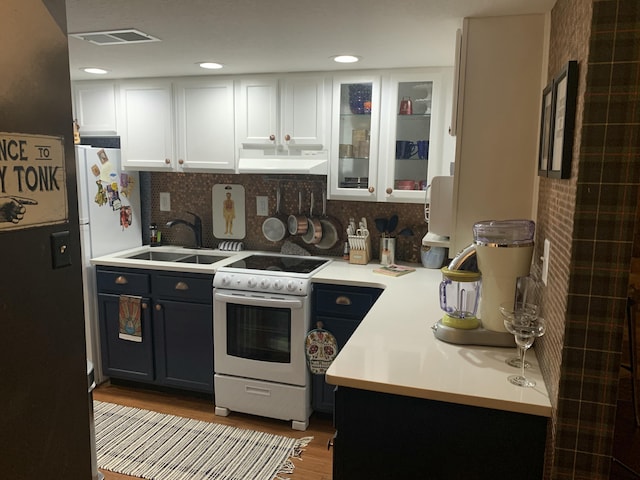 kitchen featuring visible vents, under cabinet range hood, electric range, white cabinets, and a sink