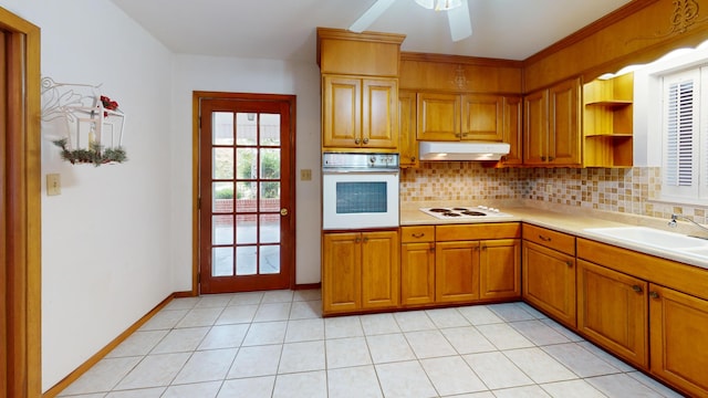 kitchen featuring white appliances, backsplash, sink, ceiling fan, and light tile patterned floors