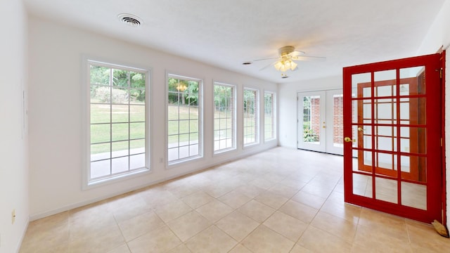 tiled empty room featuring french doors and ceiling fan