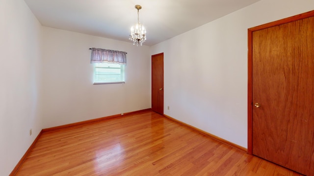 unfurnished room featuring light hardwood / wood-style flooring and a chandelier