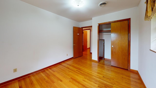 unfurnished bedroom featuring light hardwood / wood-style floors and a closet