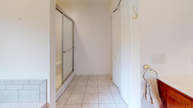 bathroom featuring tile patterned flooring, vanity, and a shower with shower door