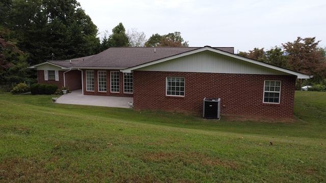 rear view of property with central air condition unit, a yard, and a patio