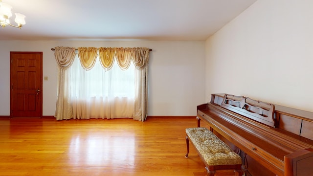 misc room featuring hardwood / wood-style flooring and an inviting chandelier