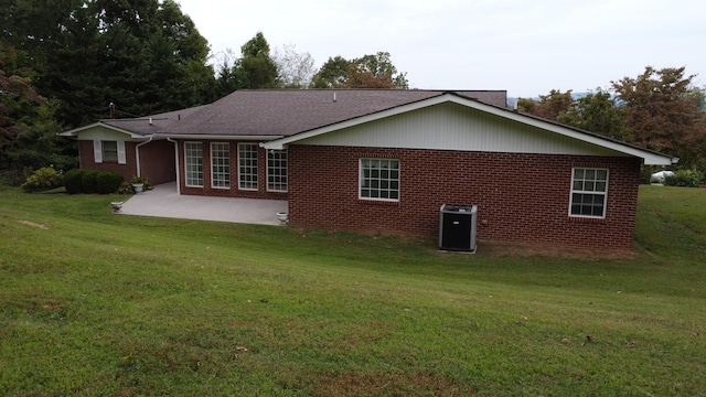 back of property featuring a lawn, cooling unit, and a patio area