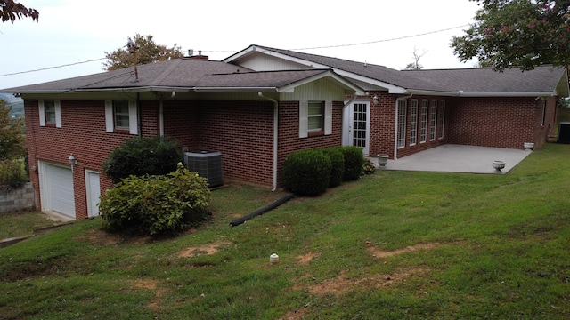 exterior space featuring central air condition unit, a front lawn, and a garage