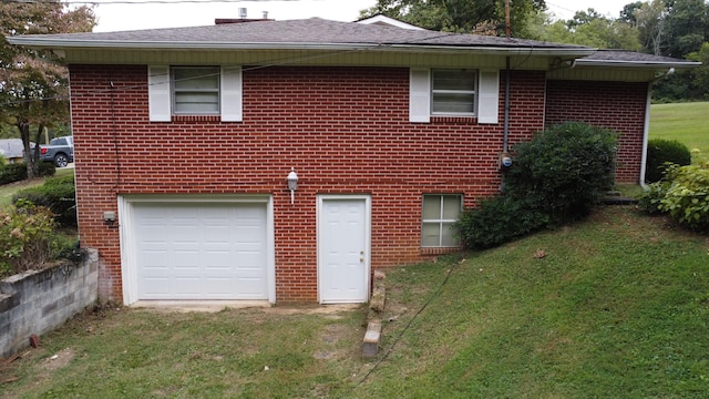 rear view of house with a yard and a garage