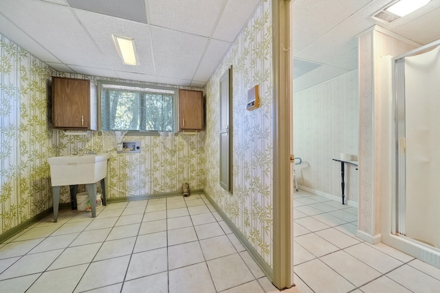 bathroom with a paneled ceiling and tile patterned floors