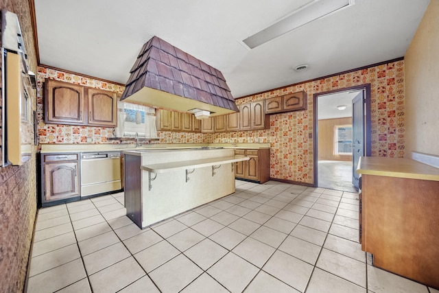 kitchen featuring a breakfast bar area, a center island, dishwasher, and light tile patterned flooring