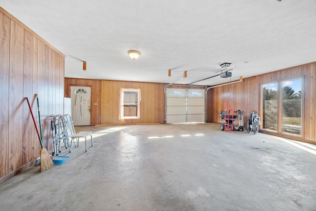 garage featuring a garage door opener and wood walls