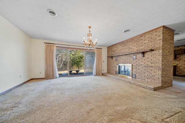 unfurnished living room with an inviting chandelier, light carpet, a textured ceiling, and a fireplace